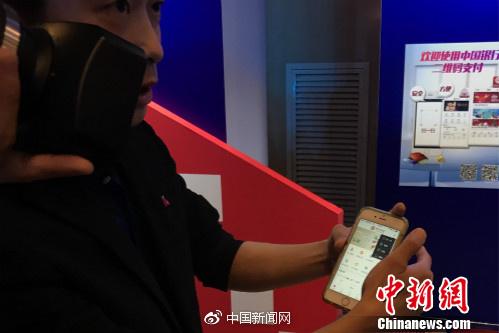 一位工作人员正在教体验者使用银联云闪付产品。中新网种卿摄