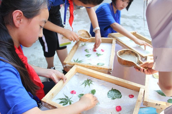 营员们正在体验中国古代四大发明之一的造纸术