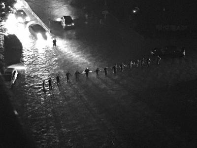 暴雨中，抢险队员站成“人墙”，引导交通。刘瑜摄 