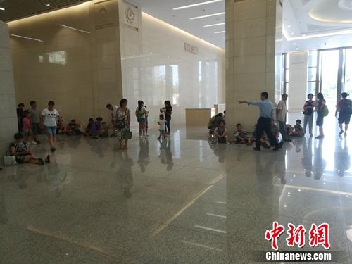 军博一层大厅也有一些参观者坐在地上，工作人员正在劝他们不要席地而坐。上官云 摄