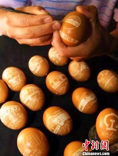 王剑用刻刀在蛋壳上记录中国铁路事业发展?！≈有?摄