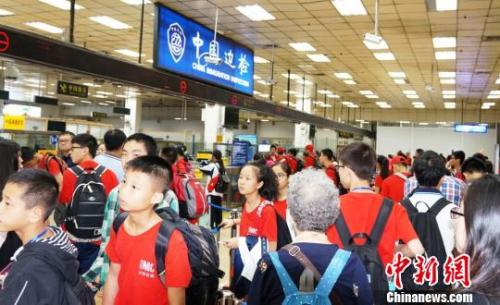 皇岗边检站增开通道快速为前往新加坡游学返程的三百余名广西柳州的小学、中学生旅游团办理入境手续。　黄俊生 摄