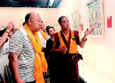     中国工艺美术大师和国家级非物质文化遗产代表性传承人更登达吉（右）向来宾介绍展品。