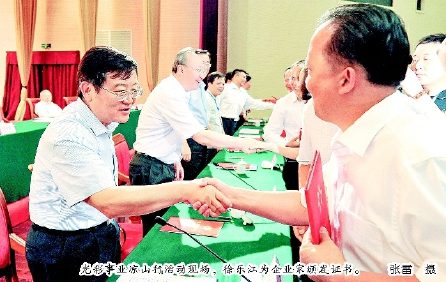 光彩事业凉山行活动现场，徐乐江为企业家颁发证书。  张雷  摄