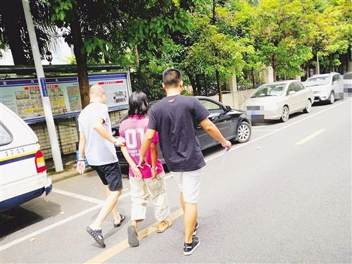 男子(中)被警方带去指认现场 本报记者 潘国武 摄 男子(中)被警方带去指认现场 本报记者 潘国武 摄