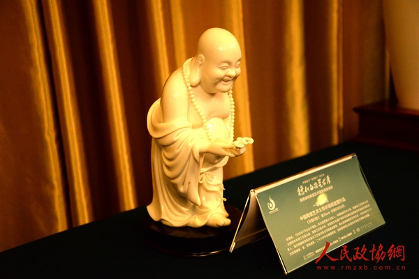 图为现场展出的德化白瓷作品：瓷塑《引福归堂》。