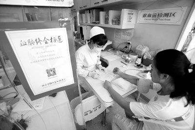 昨天，西单献血小屋内，一名前来无偿献血的女子正在接受化验。这里平常日均献血人数有20至30人，暑期以来，每天降至10至15人。 实习记者 武亦彬摄