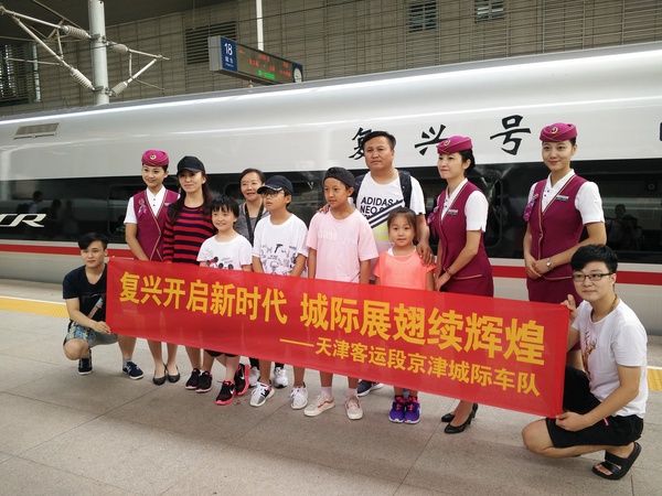 京津城际迎来“复兴号“，旅客与乘务员合影留念