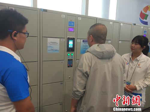 志愿者帮助记者使用电子储物柜。