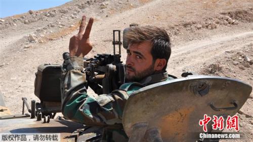 2017年8月19日，一名叙利亚军人在与极端组织的战斗中。在坦克上比出手势。