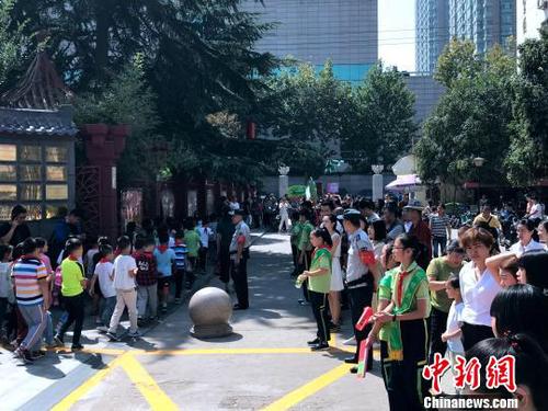 图为学校门口挤满了学生家长。　梅镱泷 摄