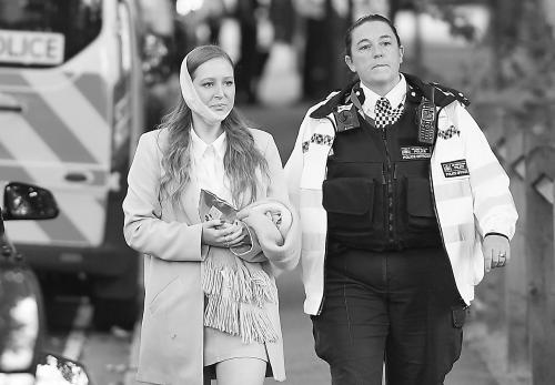 英国安全人员陪同伤者离开爆炸现场。