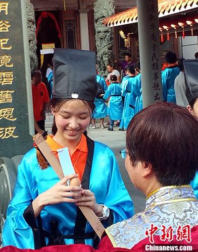 9月22日至24日，由马祖县政府与厦门陆岛旅游投资有限公司联合举办的两岸成年礼活动在马祖举行。来自福州、厦门、龙岩和马祖的260多位两岸学子参加活动。图为9月23日下午，马祖牛角五灵公庙前，“做出幼”作为本届两岸成年礼系列活动之一隆重举行。仪式上，身着汉服的马祖高中生，由长辈加冠，吃平安蛋，饮成年酒。 <a target='_blank' href='http://www.chinanews.com/'>中新社</a>记者 邢利宇 摄