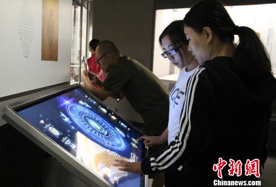 图为参展观众在现场体验互动模具?！≌韵?摄