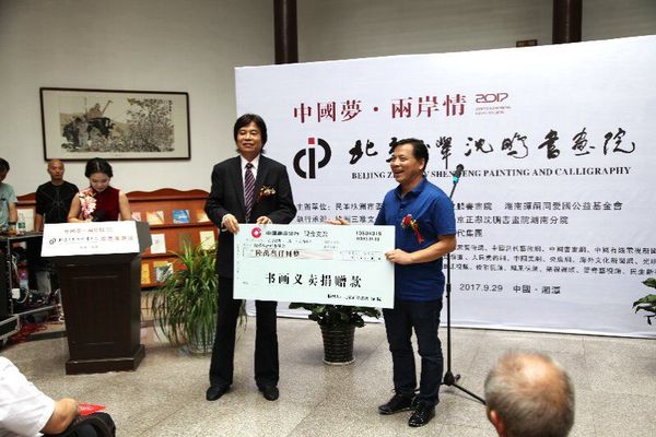 9月29日，在中国梦·两岸情画展开幕式上，民革株洲市委主委刘春正在接受北京正举沈鹏书画院院长沈鹏的义卖捐赠。