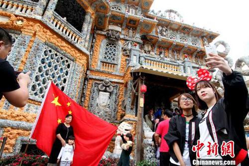 图为游客争相在国旗前合影?！≌诺勒?摄