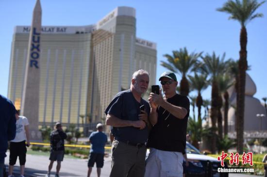当地时间10月1日晚，美国西部旅游胜地拉斯维加斯发生枪击事件，一名枪手在曼德勒海湾酒店高层向正在参加露天音乐会的人群扫射，截至当地时间10月2日中午已造成50多人死亡。警方2日在曼德勒海湾酒店四周拉起警戒线，警车和全副武装的警察严阵以待，不少媒体记者和游客也聚集于此。 <a target='_blank' href='http://www.chinanews.com/'>中新社</a>记者 张朔 摄