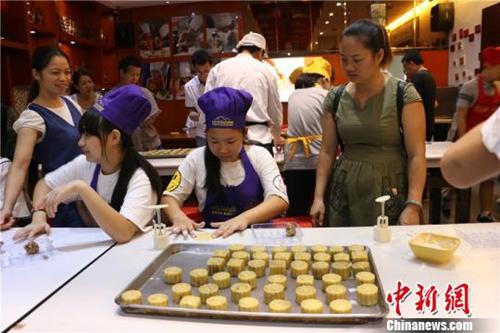 资料图:临近中秋,广西学生做月饼感受传统制饼文化。图为学生在动手制作月饼 林馨 摄 点击进入下一页