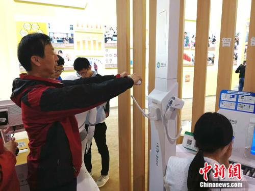 观众宋东龙体验体脂检测仪 <a target='_blank' href='http://www.chinanews.com/' >中新网</a>记者 张尼 摄 点击进入下一页