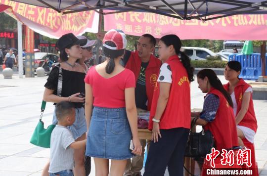 景区志愿者为游客解疑答惑、免费发放南岳旅游地图、提供景区线路指引?！∥睦龉?摄