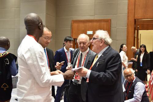 在人民日报社国际问题研究中心成立仪式上，与会专家在同马克林交流。孟祥麟摄
