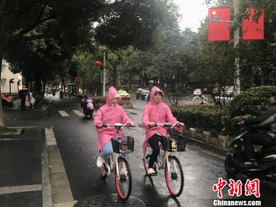11日，南京迎来降温降雨。图为市民披上雨衣出行。　杨颜慈 摄