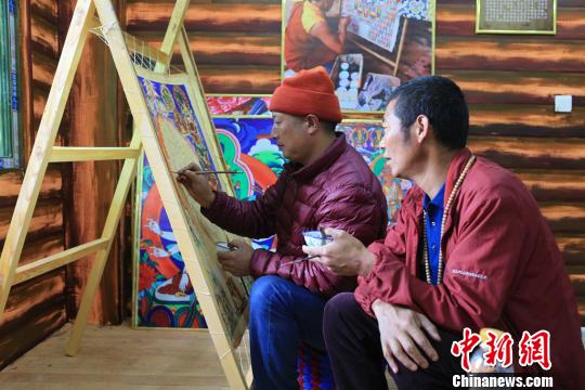 图为高佐甲泽与徒弟阿阿扎巴绘制唐卡?！⊥跖?摄