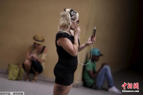 资料图片：人们拿着手机站在或坐在一个WiFi热点的附近。