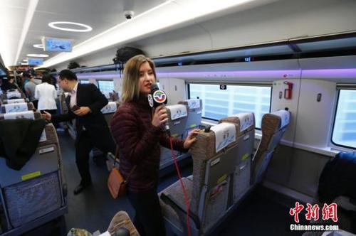 10月17日，美国中文电视台记者在京津城际高铁上采访。当日，十九大新闻中心组织中外媒体赴天津市围绕“京津冀协同发展情况”主题参观采访。采访团乘坐京津城际高速铁路赴天津文化中心、天津滨海新区中心商务区、天津申通物流公司等地，了解京津冀一体化建设在交通、商业等方面协同发展情况，以及中国高铁发展情况。 <a target='_blank' href='http://www.chinanews.com/'>中新社</a>记者 富田 摄