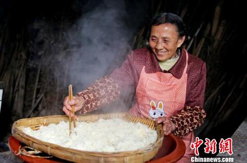 韩进先把蒸熟的糯米在筲箕中进行摊凉?！⊙钐?摄