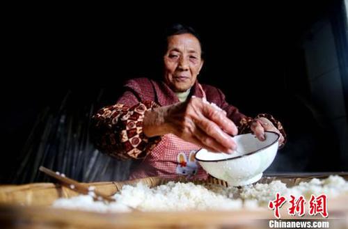 韩进先往摊凉的糯米中撒凉开水?！√瘴乃?摄