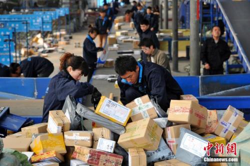 资料图：快递人员正在分拣大量包裹。 <a target='_blank' href='http://www.chinanews.com/'>中新社</a>记者 韦亮 摄