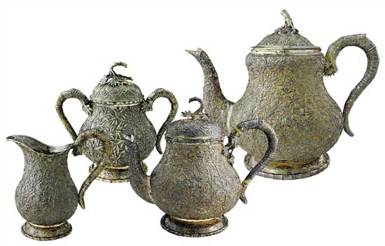 竹林摇曳茶具   Tea Set with Bamboo Forest Pattern　　咖啡壶 通高：18cm；腹径：13.5cm；重：727g   茶壶 通高：15.5cm；腹径：10.5cm；重：421g　　糖缸 通高：10.5cm；腹径：7.5cm；重：186g    奶缸 通高：9.5cm；腹径：6cm；重：131g　　款识：仪昌，伦巴 H    这套茶具使用了锤碟工艺，壶身通体附有竹枝竹叶，紧密相间，具有微风摇曳之动感，壶把手和流均为竹节附竹叶型。在茶具的细节之处体现了匠人的精心设计，银制茶具导热性极强，为防止茶壶把手过烫，凡是装热饮的茶壶、咖啡壶把手处都装有一白色象牙制圆环，俗称“象牙隔热”，用以阻断把手部分的热传导，做到美观大方与实用功能同时具备。壶体留有光面盾牌用以刻族徽，壶底外圈錾刻竹叶纹，有中国梅兰竹菊的款式风格在里面。该套茶具未经任何处理进行展示，表面留有一层氧化层，专业术语称之为“包浆”，以为对比之用。晚清外销银器盛极一时，但缺乏国内市场导致其很快衰落，至民国中后期逐渐销声匿迹，一方面是由于银器造价昂贵且国人没有使用银制器物的习惯，而另一方面则是银器需要大量的时间与精力进行维护，如若不经常擦拭，很容易表面氧化而失去光泽，这也使得银器的使用成本进一步提高，这正是银器逐渐没落的原因。可惜的是，中国传统手工业的传承大都是师徒制，而缺乏了市场需求的银器匠人招不到学徒，精湛的工艺面临着失传的窘境。