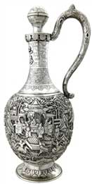 醒酒壶   Wine Decanter 晚清 通高：30.5cm；腹径：13cm；重：774g 款识：大吉     这件银壶造型独特，长颈鼓腹，通身锤揲有人物故事纹，颈部更錾刻有蕉叶纹、葡萄纹、竹枝纹，并贴焊“巴为刍夫”四字。整件器物仅有上方一球状壶塞的壶口，并无设计流口，都说明这并非盛装饮品的茶壶，而是一件醒酒壶。西方人不仅爱喝茶，同样也爱美酒，且更多的是饮用葡萄酒，葡萄酒内富含的单宁酸常?；崾咕破烦⒌目诟斜渖?，这也是葡萄酒需要“醒酒”这一程序的由来，而中国银匠为满足西方人的饮酒需要，创作出了银制的醒酒壶。有趣的是，醒酒需要让酒尽可能大面积的与空气接触，使得酒类的单宁酸迅速氧化挥发，而该壶并无此特点，这也是由于当时的银匠缺乏对葡萄酒的相关知识而造成的失误，只知有“醒酒”这道工序，而不知醒酒的原理，可谓是时代造就的一个美丽的误会。