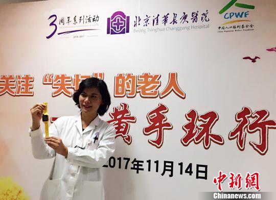 北京清华长庚医院首批29位患阿尔茨海默病的患者发放免费“黄手环”。图为北京清华长庚医院神经内科副主任医师张菁介绍“黄手环”用法?！《叛?摄
