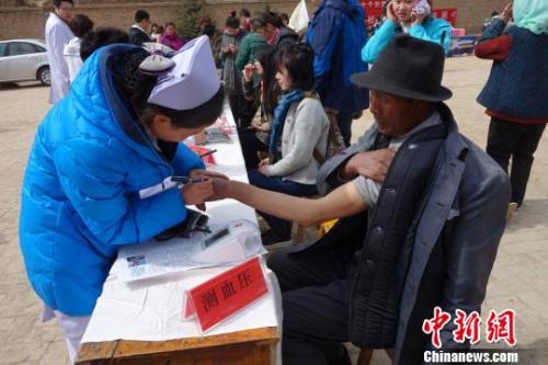 资料图：医疗志愿服务队对当地群众测量血压。　孙睿 摄