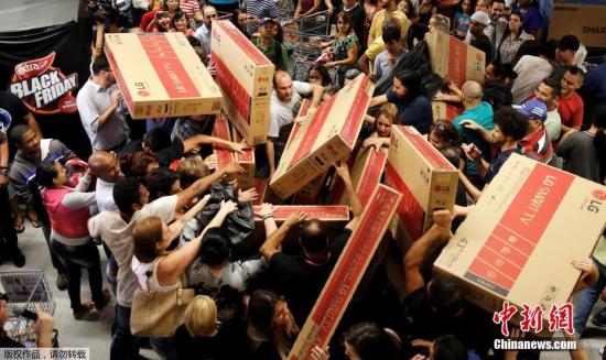 资料图：2016年11月25日，各国消费者迎来“黑色星期五”折扣日，民众倾巢出动来到大卖场，选购自己心水的货物。在众多商品中，大屏电视颇受青睐，几乎在每个卖场都能看到怀抱大电视的消费者。图为巴西圣保罗的一家商场里，大屏电视成为热门商品。