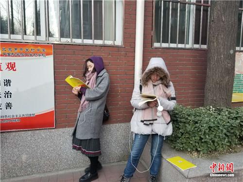 12月10日早7时30分许，北京市中关村中学(双榆树校区)，两名考生在室外进行考前复习。冷昊阳摄