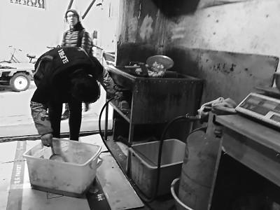 店老板在调整煤气灶的火苗。