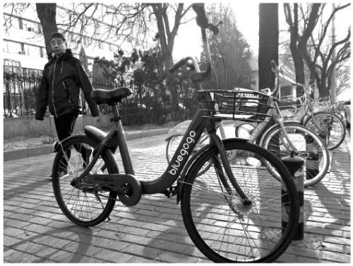 12月10日，在北京市朝阳区阜通东大街，一名行人从共享单车旁边走过。一度成排摆放的小蓝单车，如今只能偶尔见到。