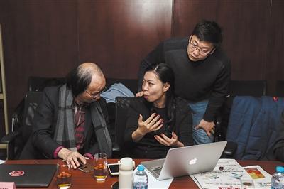 12月16日，2022年冬奥特许商品评审会现场，特许生产商与会徽设计者林存真(中)交流特许商品的改进思路。图片来源：新京报