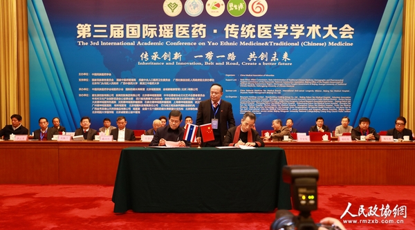 泰国前副总理、泰中友好协会会长功·塔帕朗西（左）与北京瑶医医院院长覃迅云（右）签约“一带一路健康家园，中泰文化交流项目”