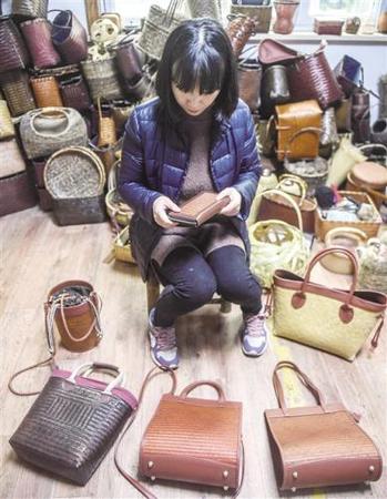 浙江省安吉县鄣吴镇依托青山、绿水、竹林，发展“绿色经济”。11月30日，鄣吴安吉心然竹木工艺品工作室负责人王蓉在查看手工竹编包。 新华社记者 徐 昱摄