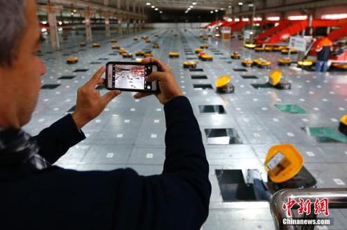 10月17日，中外媒体参观天津申通物流公司的“小黄人”分拣中心。当日，十九大新闻中心组织中外媒体赴天津市围绕“京津冀协同发展情况”主题参观采访。采访团乘坐京津城际高速铁路赴天津文化中心、天津滨海新区中心商务区、天津申通物流公司等地，了解京津冀一体化建设在交通、商业等方面协同发展情况，以及中国高铁发展情况。
<a target='_blank' href='http://www.chinanews.com/'>中新社</a>记者 富田 摄