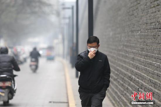 资料图:雾霾天气市民戴口罩出行。张远 摄 点击进入下一页