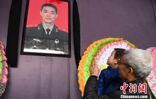 2岁多的儿子在吴俊寰遗像前?！×踔铱?摄