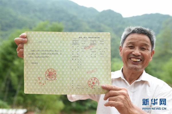 　福建武平县万安镇捷文村村民李桂林展示林权改革后领到的全国第一本新式林权证（2017年6月16日摄）。