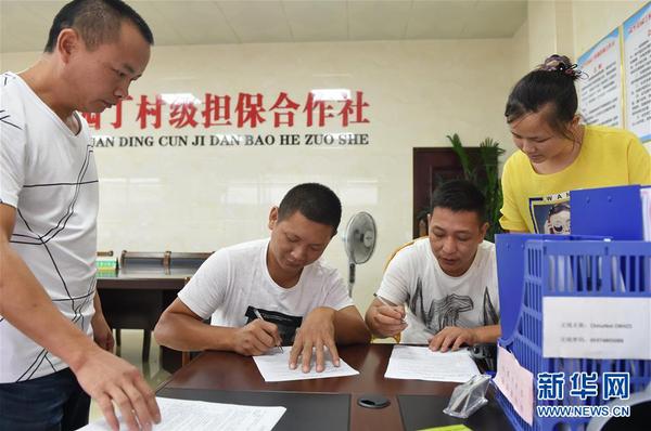 两名村民在福建武平县城厢镇园丁村村级担保合作社签订反担保合同（2017年6月15日摄）。