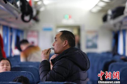 车厢内旅客刮起了胡子。　殷立勤 摄