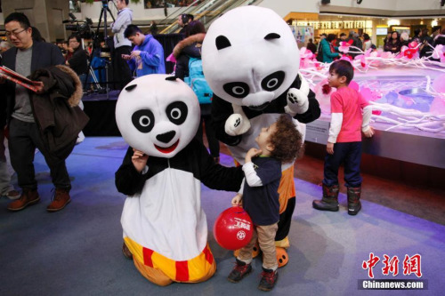 当地时间2月11日，加拿大第二大城市蒙特利尔举行欢乐春节庙会。图为现场工作人员扮演的“大熊猫”吸引当地“洋娃娃”的目光。这是蒙城连续第二年在农历新年前夕由华人社区联合举办欢乐春节庙会。参与筹办庙会的侨团由第一届的70多个增至本届的近百个。<a target='_blank' href='http://www.chinanews.com/'>中新社</a>记者 余瑞冬 摄